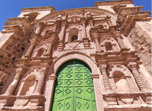 Portada del Templo Santiago Apóstol con puerta de madera verde y fachada barroca de piedra finamente ornamentada